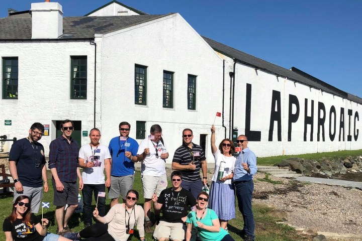 people showing flags in front of a distillery in Scotland